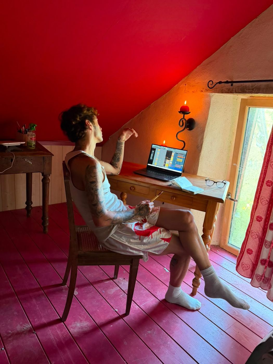 Deren Gigi producing on a laptop in a red attic studio
